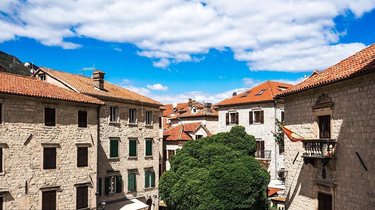 tiny town in Montenegro Bay of Kotor, old stone buildings, coastal cliffs, historic architecture, Mediterranean scenery