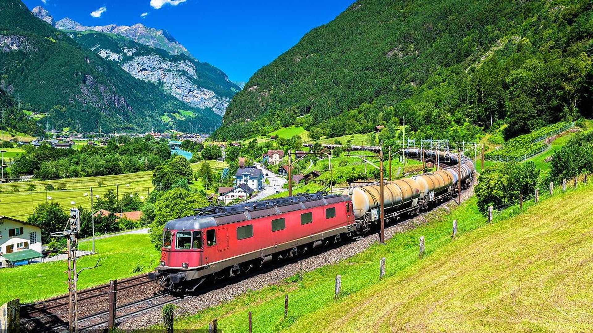 regional train traveling through scenic european countryside with mountains and small towns